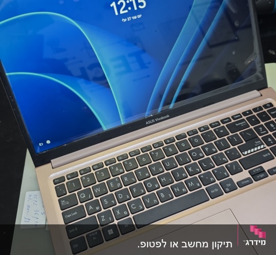 מחשב נייד על שולחן עם מסך דולק